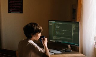 A child sitting at a desk playing a video game Description automatically generated with low confidence