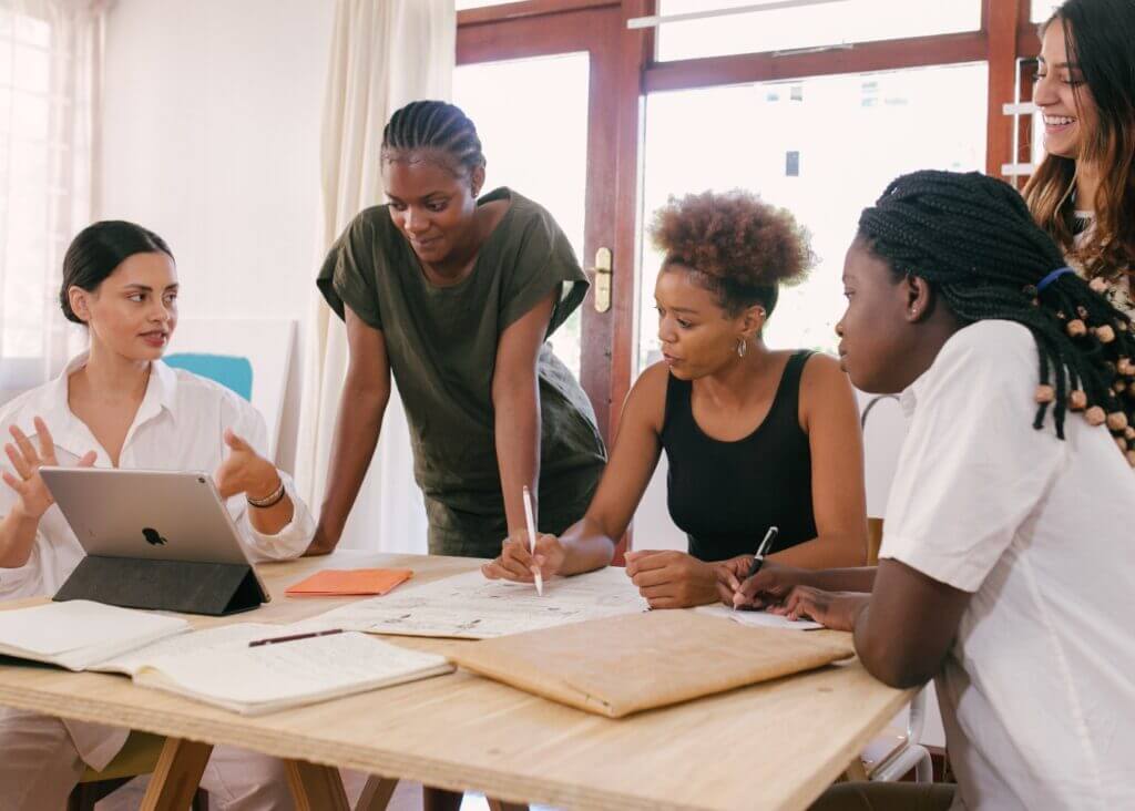 A group of people in a meeting Description automatically generated with low confidence